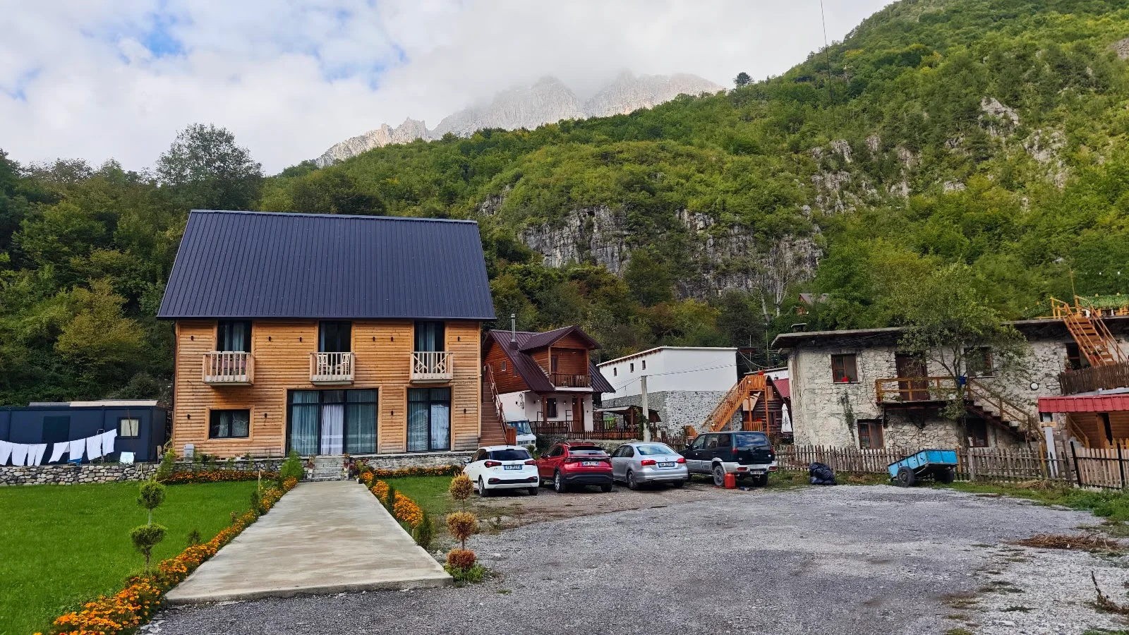 Modern balconied timber guesthouse below snow-dusted peaks at Fryma e Bjeshkeve in Theth