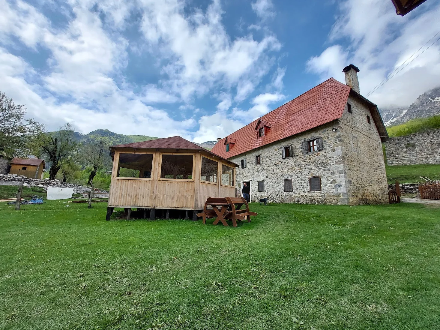 Stone farmhouse and wooden garden pavilion of Bujtina Terthorja in the Theth valley