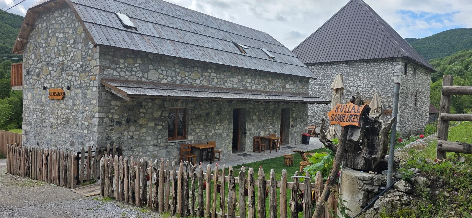 Restored traditional stone kulla tower house with signage at Kulla e Sadri Lukes in Okol, Theth