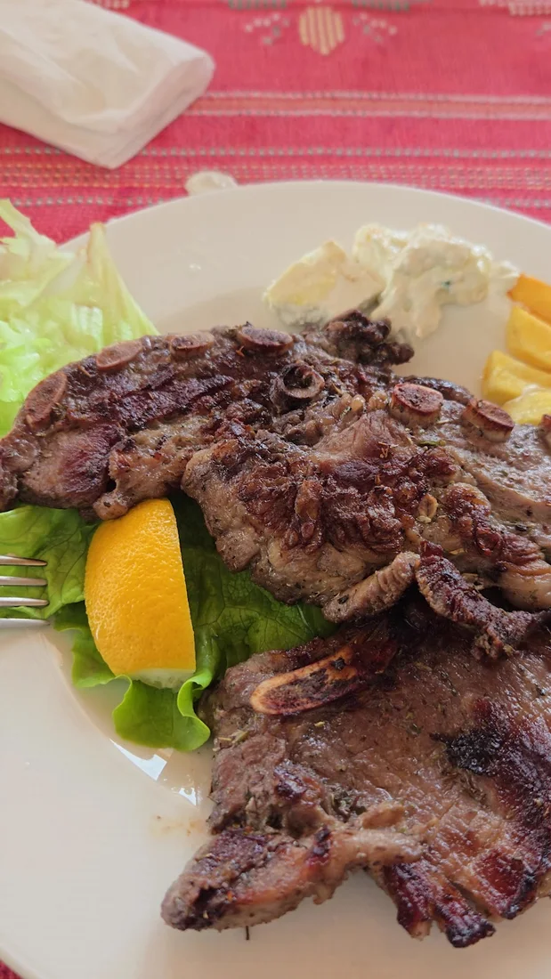 Plate of grilled lamb chops with salad and cheese at Buni i Bajraktarit near the Qafë Thore pass above Theth