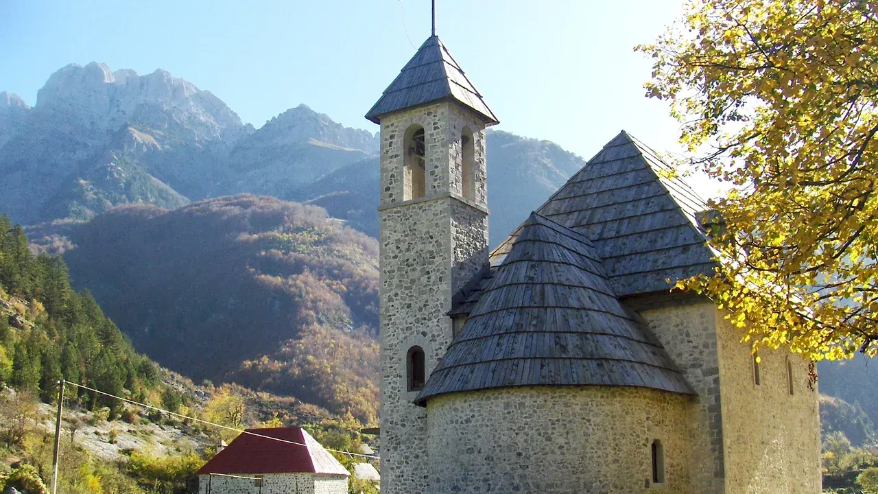 The stone church of Theth beneath the peaks of the Accursed Mountains