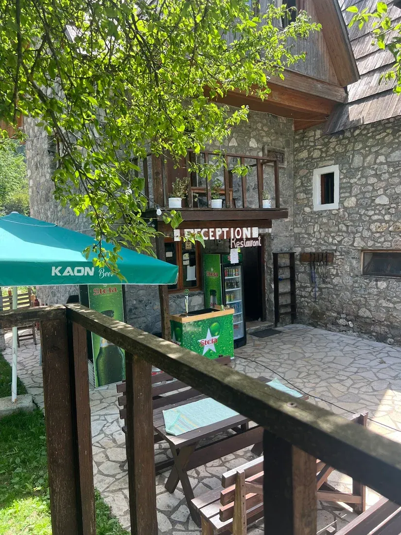 Stone-flagged terrace and reception of Shpella Guesthouse in Theth