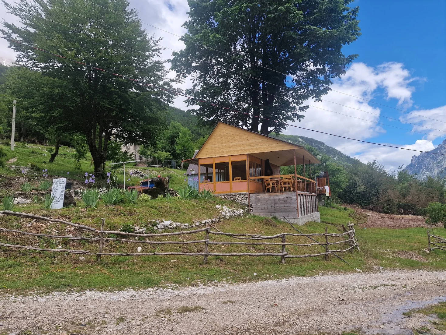 Timber bar-restaurant and guesthouse on a meadow below the peaks at Guest House Leka in Rrogam, Valbona