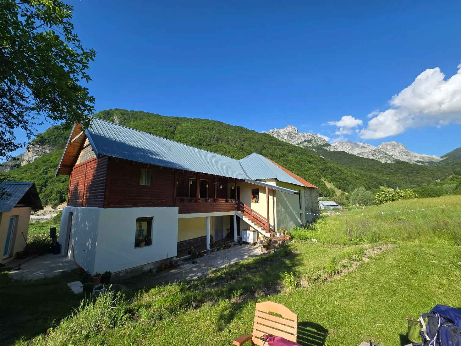 Timber-and-plaster guesthouse on a green meadow below the peaks at Guesthouse Relax in Çerem, Valbona