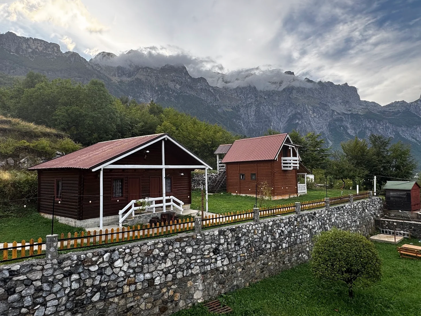 Timber chalets of Thethi Paradise below the peaks of the Accursed Mountains in Theth