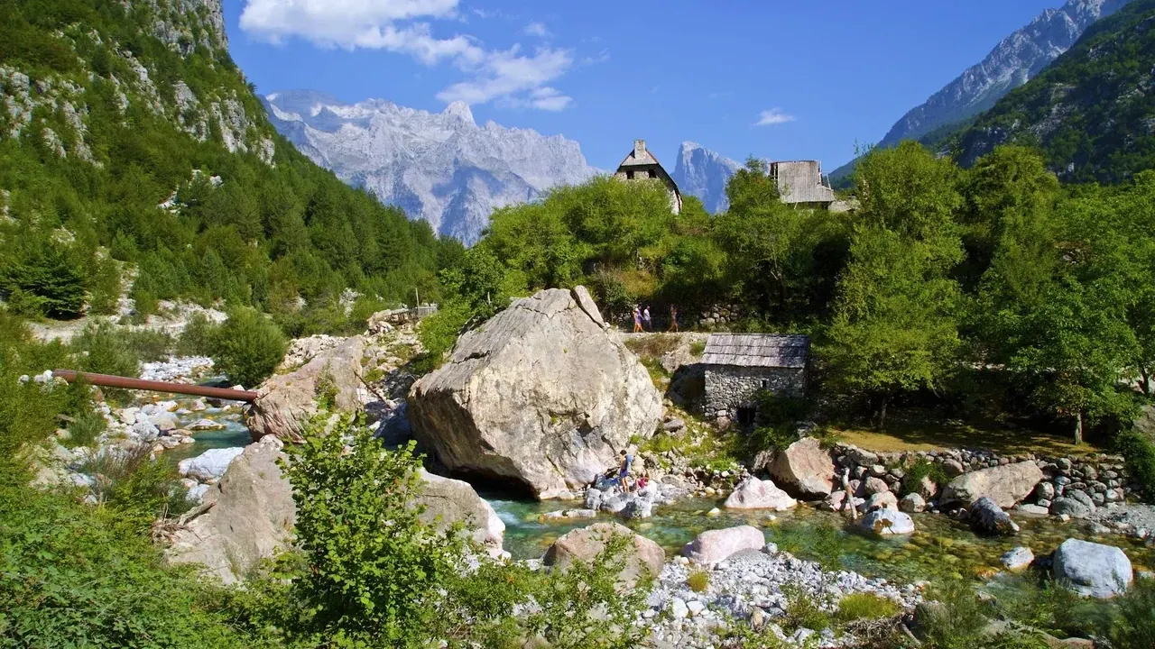 Theth village and its guesthouses in the valley below the Alps